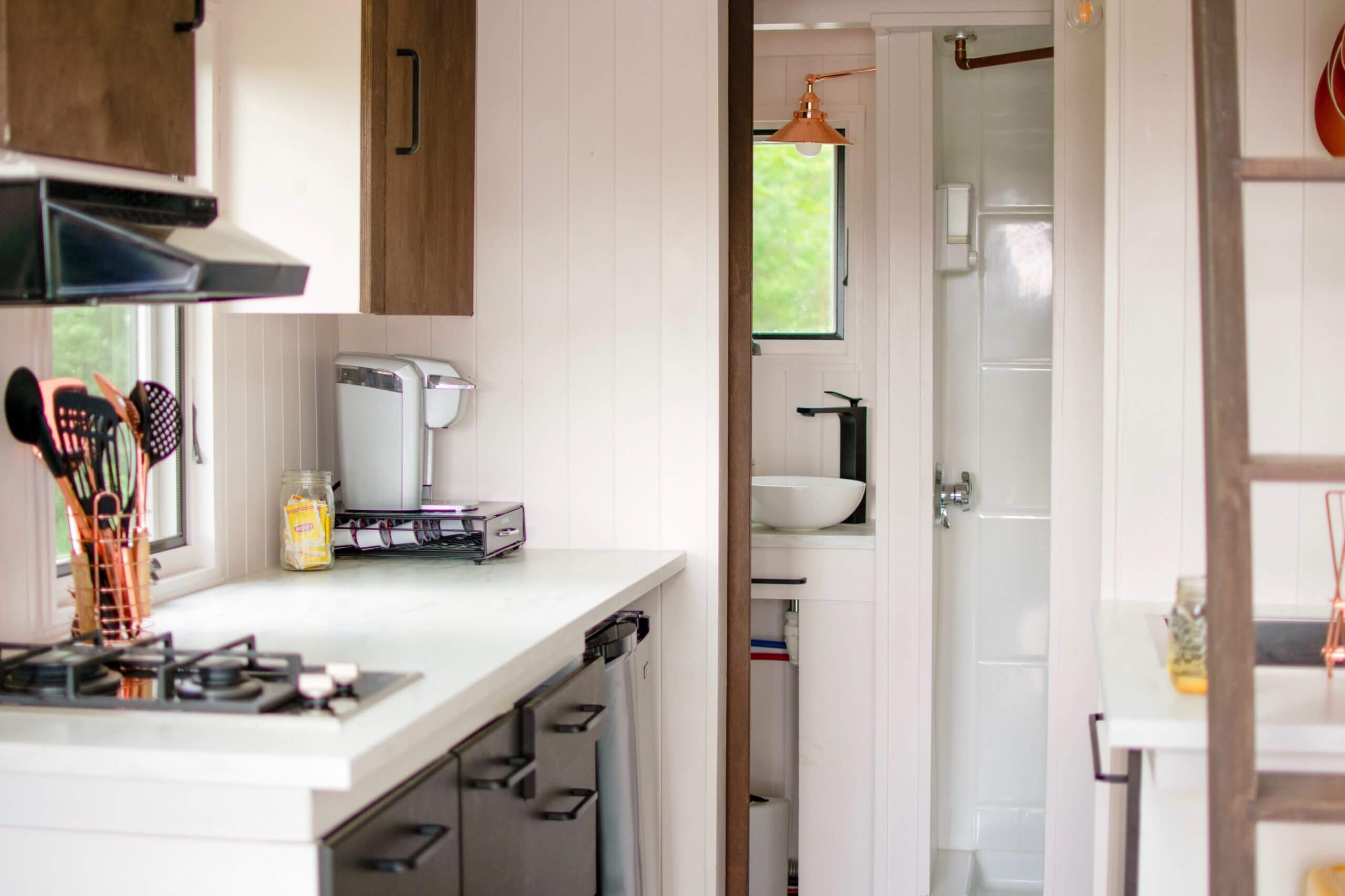 Inside of tiny home showing kitchenette and glimpse of bathroom
